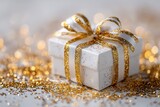 A luxurious white gift box adorned with sparkling gold ribbon and glitter.