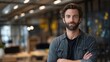 © LORD - Confident Caucasian man with a beard stands in a modern office, arms crossed, exuding professionalism and approachability.