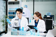 © Nuttapong punna - Team of scientists analyzing blue liquid samples in a modern lab, showcasing biotechnology, chemistry, and medical research innovation.