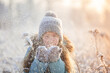© Tatyana Gladskih - Child walking at winter park. Kid enjoys the snow and the beautiful weather. Happy girl play with snow