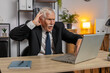 © Andrii Iemelianenko - Frustrated senior businessman having software problems with laptop angry grandpa nervous seeing error, mistake notification at computer screen mad employee experience virus attack or app malfunction.