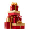 © AN STOCK - A vertical stack of red and gold Christmas gifts, each tied with a contrasting ribbon, creating a towering display. High-end product photography, clean lighting, isolated on white background.