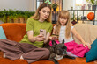 © Andrii Iemelianenko - Mother and daughter with French bulldog at home learn safe online card payment set rules and limit. Woman and girl with dog on sofa show okay gesture teach security steps avoid fraud confirm lesson