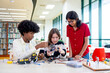 © narong - Multiracial teen girl explain about how to assemble the robot and discuss with friends in public library.