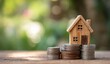 © Selvi - Small wooden house model on stacked coins representing real estate investment