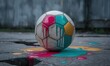 © irawan710 - A weathered soccer ball, half painted with vibrant colors, sits on cracked pavement