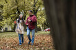 © Dejan - A joyful couple enjoys a leisurely walk through a picturesque autumn park filled with vibrant fall foliage and warm tones.