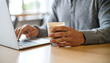 © Helios - A man working with his remote job and enjoying cup of coffee latte in the cafe