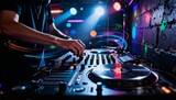 DJ mixing music on a turntable and mixer console. Live performance in a nightclub with colorful lights. Electronic music and party entertainment concept