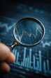© Georgii - Hand inspecting financial graph through magnifying glass on a digital screen