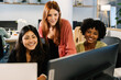 © Xavier Lorenzo - Three young diverse professional businesswomen gathered around laptop in the office, collaborating and discussing ideas for a shared project. Teamwork and business concept