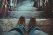 © juliars - Worker wearing brown boots and jeans standing at the top of a grungy staircase, point of view shot