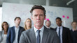 © Oleksandr - Focused leader with team, showcasing determination. The mature man in the forefront exudes authority, while the diverse group in the back represents unity.