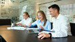 © muse studio - Team collaborating on a project in a modern office space with laptops and documents