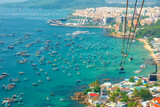 Aerial view of An Thoi harbor with coastal fishermen village, fishing boats, turquoise sea and modern cable car ride on Phu Quoc island, Vietnam. Modern Hon Thom cable car cabin