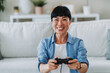 © Miljan Živković - Excited woman winning a video game at home and raising an arm