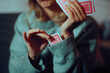 © nicoletaionescu - Woman Plays Cards Puts a Card Up Her Sleeve to Cheat. Deceptive game player trying dishonest tactics