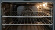 © photoplotnikov - Interior of a modern stainless steel oven with dual shelves and light on