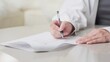 © mapo - 契約書にサインをするアジア人女性の手元