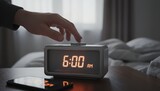 Person turning off alarm clock at 6 AM
