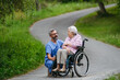 © Halfpoint - Senior patient and male nurse talking during walk outdoors.