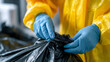 © Narmin - A person carefully separates hazardous materials into a black trash bag for proper disposal and recycling