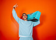 © VISTA by Westend61 - Man in blue outfit holding boombox against orange background having fun