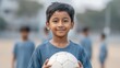 © 69 - Happy Young Indian Boy Smiling with a Soccer Ball in His Hand at a Playful Outdoor Setting Capturing Joyful Moments of Childhood Activity