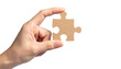 © photostockatinat - A hand holding a single jigsaw puzzle piece, symbolizing problem-solving and completeness. The piece has a unique shape and is ready to be integrated