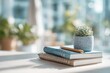 © whitestorm - Peaceful desk setup: succulent, notebooks, and pencil in bright natural light.