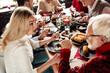 © deagreez - Family gathers for a festive Christmas dinner around a decorated table with candles and warm holiday atmosphere