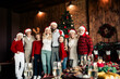 © deagreez - Family Christmas gathering by the tree with festive decorations and warm lights celebrating together in cozy home interior