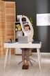 © New Africa - Young businesswoman stretching her arms and back at table in office