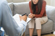 © KMPZZZ - Psychology, depression. Suffer asian young woman consultation with psychologist while patient counseling mental therapy, doctor hand taking notes at clinic. Psychologist with sick mental health person