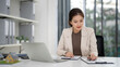 © snowing12 - Asian property agent diligently analyzes real estate market data planning strategic sales in a contemporary office setting