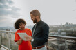 © Halfpoint - Real estate agent talking to client on the rooftop of a modern building
