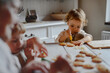 © Halfpoint - Family holiday baking with grandma in cozy kitchen.