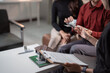 © Tj - Couple completing a real estate transaction, counting money for a down payment to an agent during a meeting, with house model and contract on the table