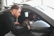 © Serhii - Car salesman showing new vehicle to african american customer in dealership