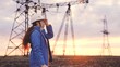 © TO LOVE - An engineer at a high-voltage power plant is working making an inspection at the sunset in the sky, electricity design, industry concept, modern business technology, an electrician with a project on