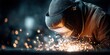 © FocusFusion - Welder Wearing Protective Gear Focused on Welding Metal With Sparks Flying in a Dark Workshop