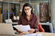 © Stock 4 You - Focused latin hispanic business woman working on laptop computer reading financial document trader report in office. Thinking accountant entrepreneur manager businesswoman doing paperwork using pc
