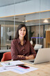 © Stock 4 You - Vertical portrait young it specialist latin hispanic business lady working on laptop pc sitting at desk in modern office smiling at camera. Middle eastern indian woman using computer for work online