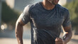© PinkyEn - Close-Up of a Man Jogging Outdoors with his T-shirt wet from sweat. Droplets of sweat and sunlight emphasize the intensity and energy of the workout.