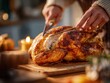 © Anastasiya Ri - Golden roasted turkey being sliced on a wooden board in warm kitchen light perfect for Thanksgiving dinner visuals, festive meal backgrounds and holiday food concepts
