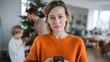 © milkyway - Woman holding smartphone with family decorating Christmas tree in cozy home