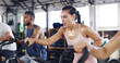 © peopleimages.com - Spin class, exercise and earphones with woman in gym for intense workout, music and cycling challenge. Fitness, streaming and stationary bike machine with people in sports club with sweat and energy