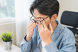 © KMPZZZ - Eye problem concept, fatigue asian young man tired eyes, irritated rubbing eye dry relief vision pain after work on laptop computer, eye strain, while wearing glasses, suffer migraine, bad blurry.