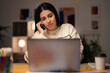 © Studio Marmellata - Young Arab female remote employee in casual clothes speaking via smartphone with client while working on project remotely using laptop