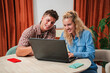 © Jose Calsina - A cheerful couple engaging in a productive session while working on a laptop, sharing smiles and laughter in a cozy atmosphere, showcasing a joyful interaction with technology and each other.
